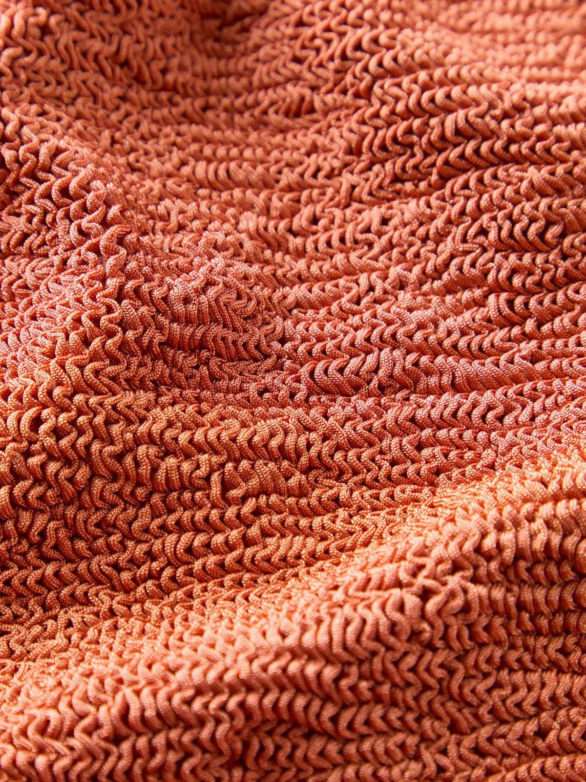 Fabric close up of metallic terracotta halterneck